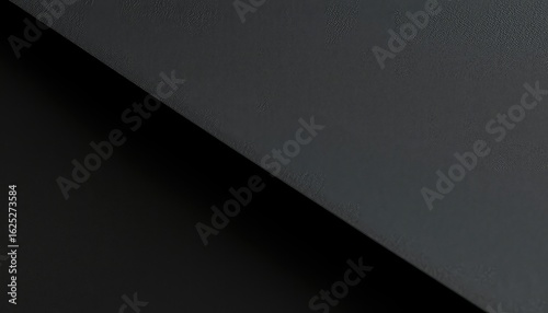 Monochromatic texture showing a stark diagonal contrast between dark gray surface and solid black, emphasizing shape and light