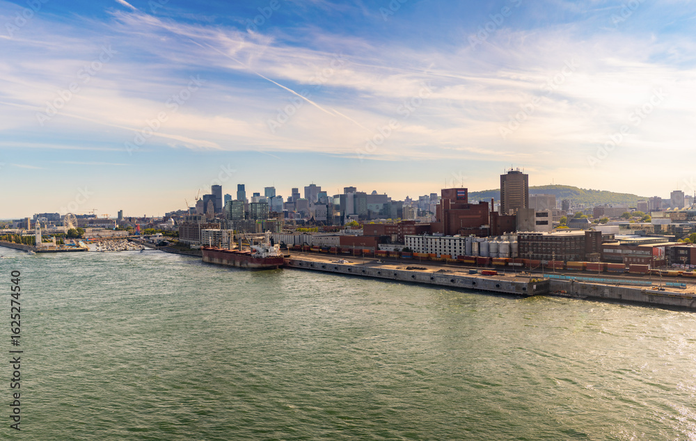 Naklejka premium A wide view of Montreal from afar, showcasing the city’s downtown skyline with modern buildings and urban landscape.