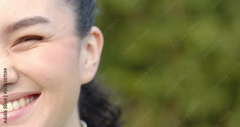 Close-up showing woman shifting from neutral to smiling, laughing in garden copy space Close-up showing woman shifting from neutral to smiling, laughing in garden copy space