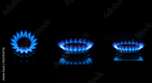 Captivating blue gas flames dance vibrantly on a sleek black stovetop, creating a modern, sophisticated ambiance perfect for culinary inspiration and home design.