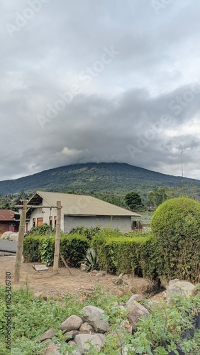 Tropical rural house with cloudy mountain background in a peaceful countryside