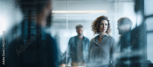 Diverse Team Brainstorming in Modern Office* — Professional multiethnic colleagues discussing IT strategy at a business meeting. Real-life corporate teamwork and innovation concept.
