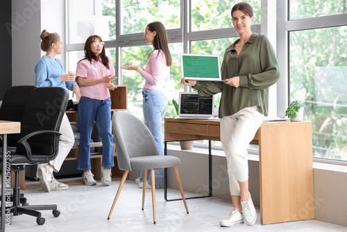 Female programmer with laptop in office
