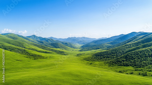Vast, lush green valley stretches between rolling hills clear blue sky, creating serene and expansive landscape. vibrant greenery contrasts beautifully with bright sky, evoking sense