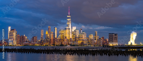 New York city. NYC cityscape. Lower Manhattan and One World Trade Center in New York Cit. Skyscrapers of Manhattan located near rippling water of New York bay against blue sky. New York skyscrapers.