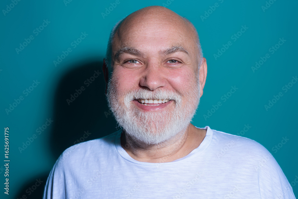 Obraz premium Portrait of Grandfather. Senior face with grey beard isolated. Close-up headshot of elderly Grandfather. Casual retired man. Grandfather 60s man studio portrait. Grandfather with grey beard.