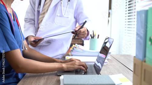 Medical Professionals Review Patient Records: A physician and a nurse meticulously review patient records. Focusing on details, the scene captures healthcare teamwork and dedication.