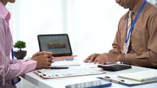 Financial Review: Two colleagues in a professional setting, engaged in a detailed financial review. a modern office.
