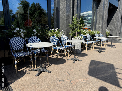 Obraz na płótnie Outdoor tables and chairs alongside cafe windows