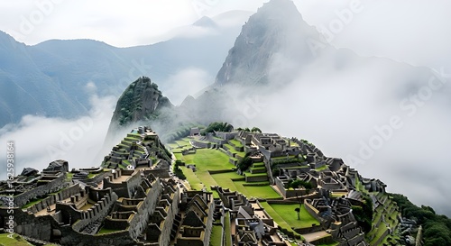 Ancient stone city nestled among towering mountains, partially obscured by clouds.