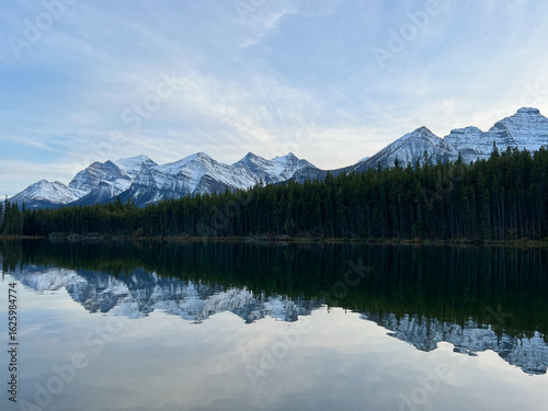 Snow Mountains and Pine Forest wtih Reflection in the Lake at Canada