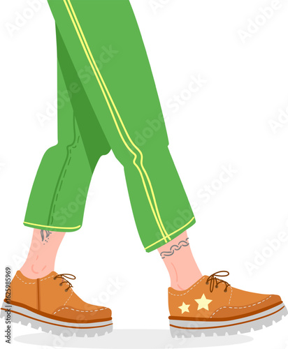 Close up of legs taking a step, showcasing trendy green pants with yellow stripes and fashionable brown shoes decorated with stars, highlighting a sense of style and movement