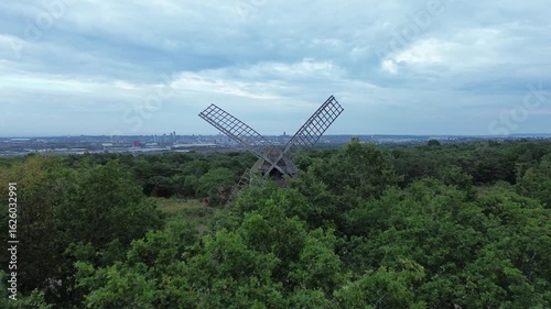 Aerial view of slow flight between stationary windmill blades
