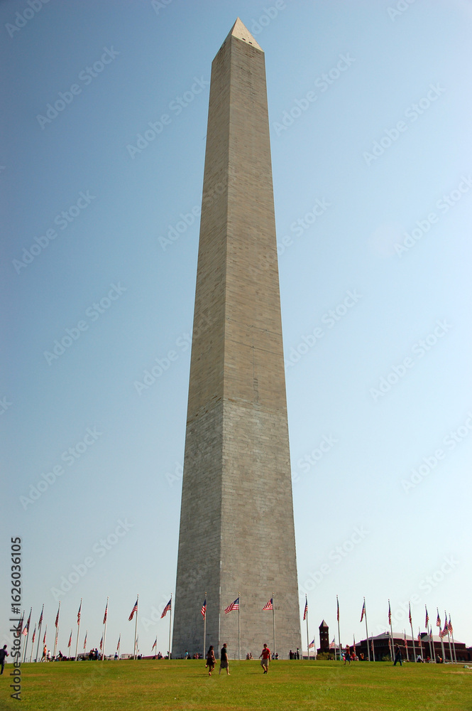 Obraz premium The Washington Monument, an iconic marble obelisk on the National Mall in Washington, D.C., honoring George Washington, surrounded by U.S. flags