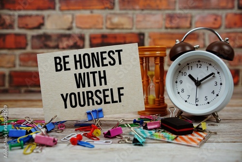 Obraz na płótnie Be honest with Yourself text on paper card with alarm clock and stationary on wo