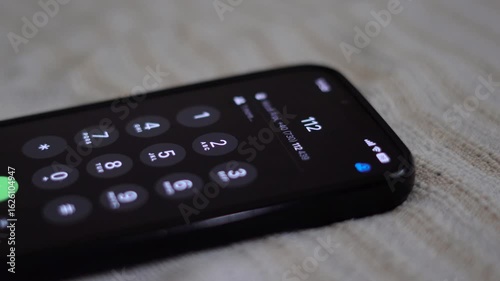 Man in need of help dialling 112 emergency number on smartphone.