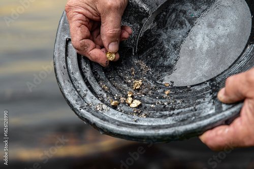 Photos Elderly man's hands holding gold sand, small pieces of gold nuggets