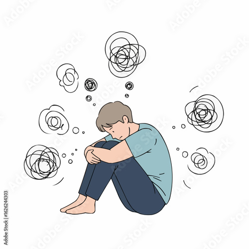 Young boy sitting with knees drawn up, appearing distressed in isolation  
