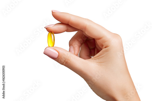 A hand holds a yellow capsule.  Close-up, soft lighting