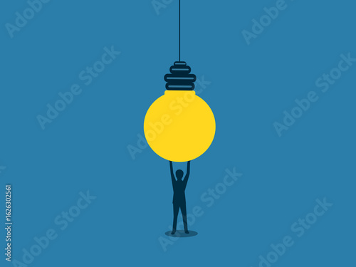 businessman holds a light bulb to replace it