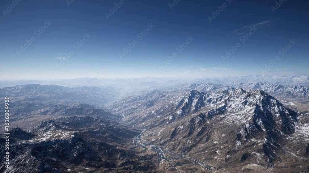 High-altitude view of rugged, snow-capped mountains and valleys High-altitude view of rugged, snow-capped mountains and valleys