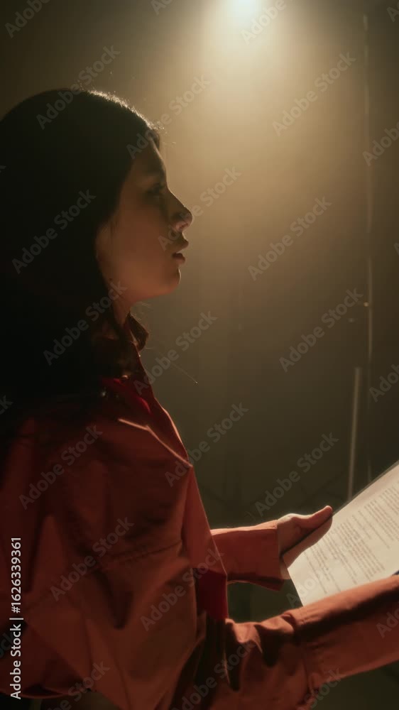 Vertical shot of young Latin actress rehearsing her lines, reading off ...