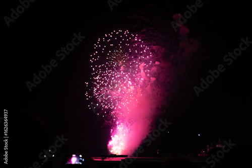 A photo of a large fireworks is lit up the night sky