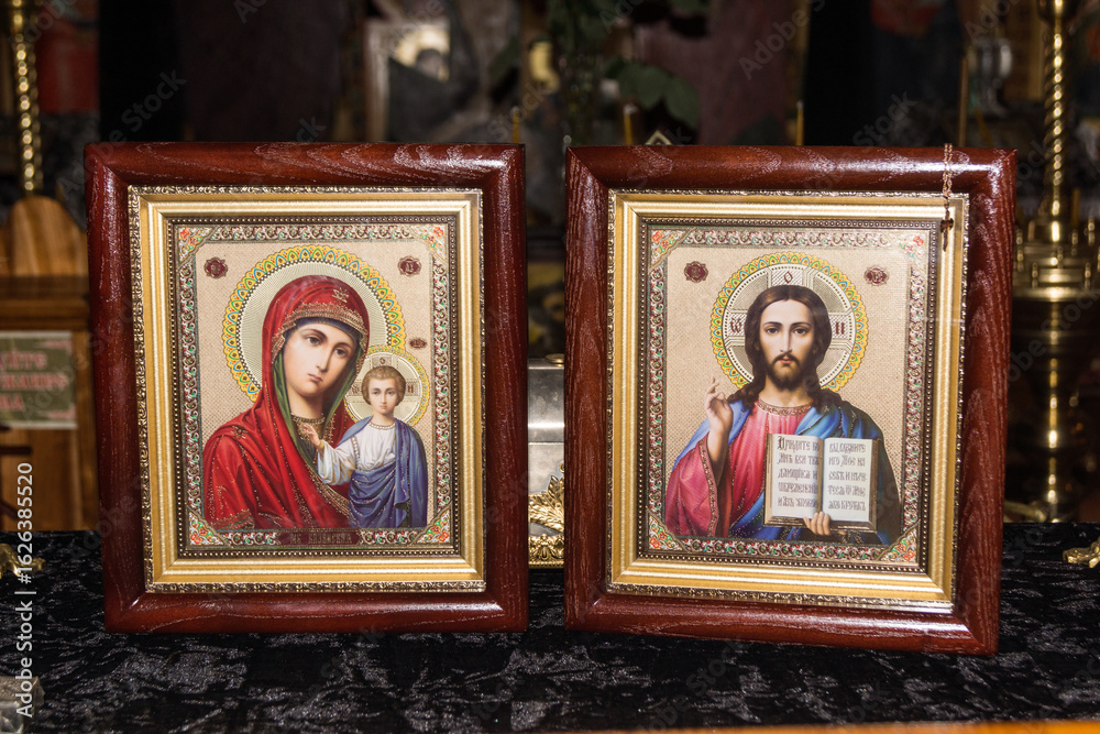 Obraz premium Religious icons of the Virgin Mary and Jesus displayed on an altar in a serene setting during evening light