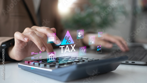 Businesswoman using calculator and laptop with virtual tax icon. Digital finance, fintech, and online tax filing concept. Professional female accountant.
