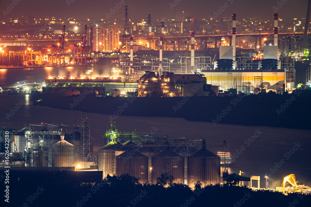 Fototapeta premium Aerial view of industrial area, factory, port and harbour in Bangkok city, Thailand at night time.