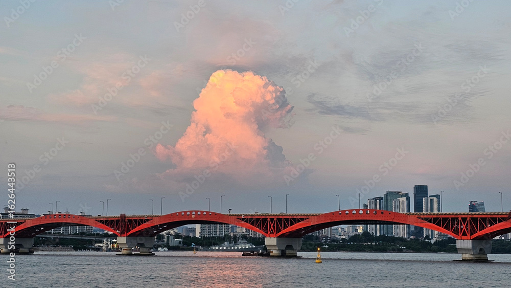 Obraz premium 서울 한강 성산대교 위로 떠오른 황금빛 뭉게구름