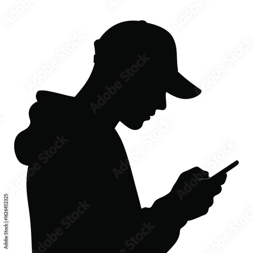 Silhouette of a young man wearing a baseball cap looking down at his smartphone