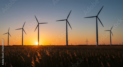 Wind Turbines Windmill Energy. Wind turbines stand in a field at sunset, harnessing wind power for renewable energy production.