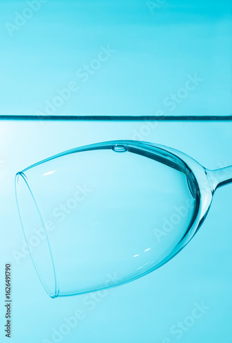 Glass in water isolated on blue background