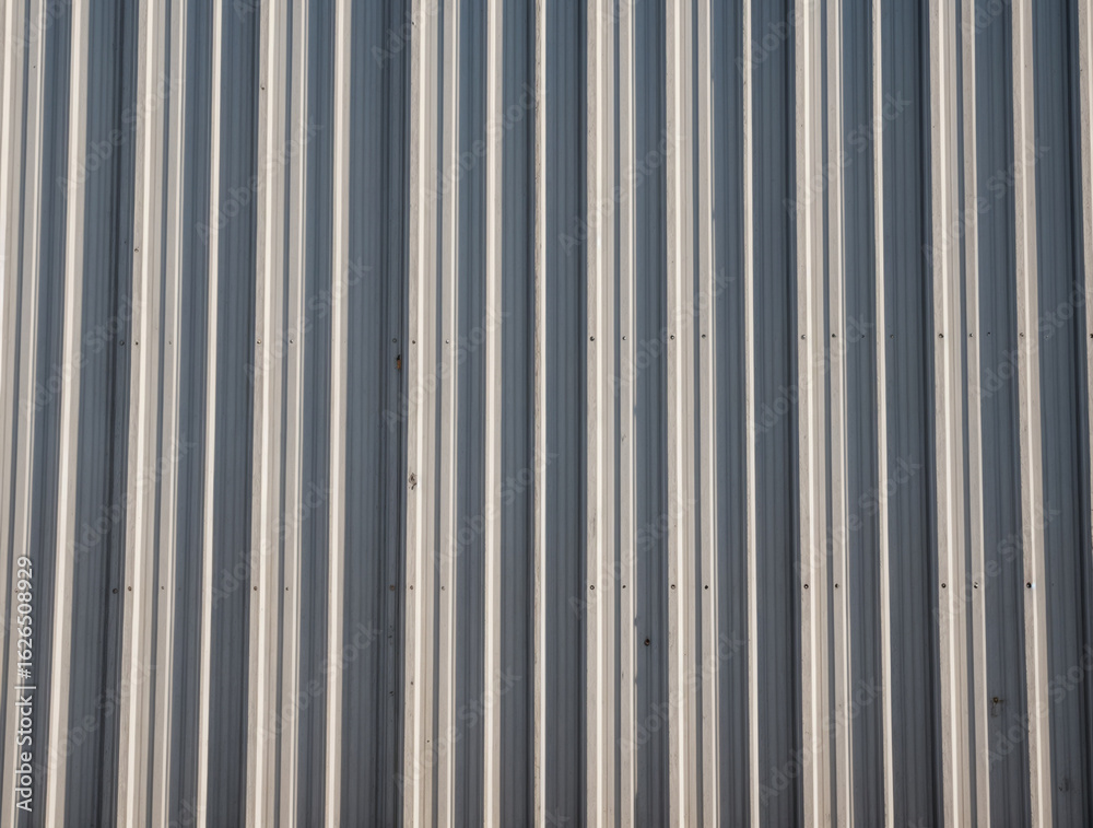 A weathered corrugated steel wall lined with grit and repetition A weathered corrugated steel wall lined with grit and repetition