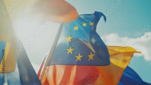 Waving European Union flags against a blue sky, symbolic unity shot