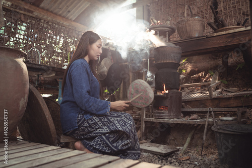 Wallpaper Mural From a low angle, this shot captures a young woman cooking, her bare feet connecting to the ground. It embodies a humble, simple, and deeply grounded approach to life and food preparation. Torontodigital.ca