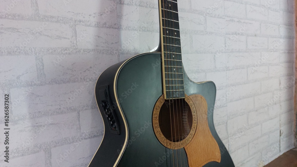Obraz premium an elegant black acoustic guitar made of rosewood, with six steel strings that produce a melodious sound.