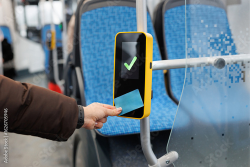 Woman hand paying contactless with plastic card for the public transport in bus. © Studio Peace