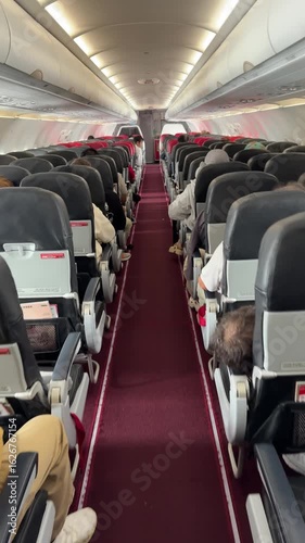 Malaysia - 05.07.2025 - Passengers boarding the plane. Red seats in the cabin of the aircraft. Time of departure. Rows of seats in the aircraft