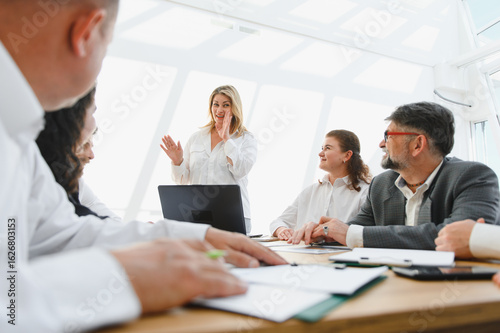 Business team celebrating success during meeting in modern office