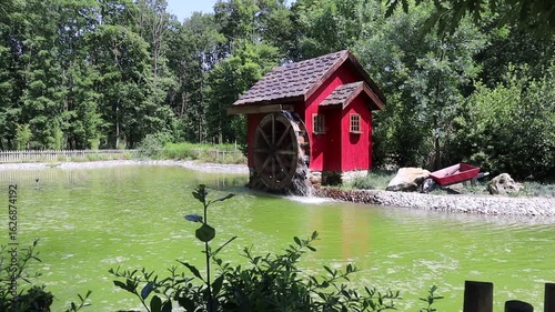 Red watermill on the shore of the lake