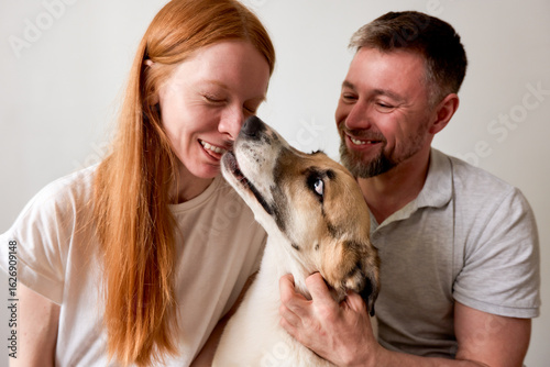 Smiling couple enjoying bonding moments with their lovable dog at home