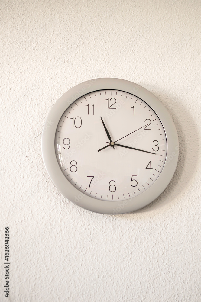 Eine Wanduhr an einer weissen Wand Eine Wanduhr an einer weissen Wand