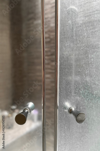 Schilderij op canvas Close-up of a dirty shower glass door with white mineral residue from hard water and soap scum