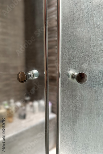 Close-up of a dirty shower glass door with white mineral residue from hard water and soap scum.Another side of the door after cleaning. Common bathroom cleaning issue.