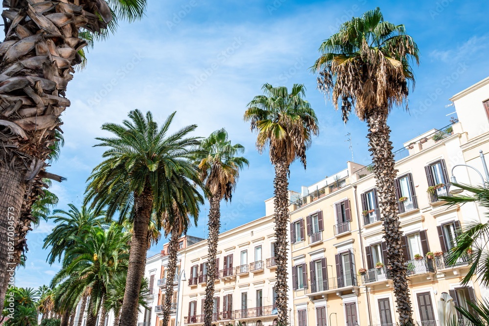 Fototapeta premium Palm trees and Mediterranean architecture under blue sky.