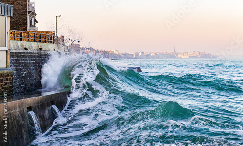 Fototapeta Naklejka Na Ścianę i Meble -  An impressive wave breaks over the sea wall in Saint-Malo