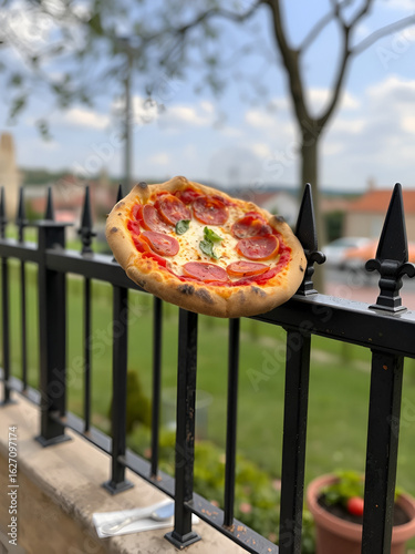 Margherita pizza impaled on iron fence