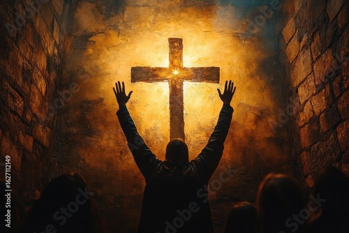 Person with raised hands worshiping or praying before a glowing cross on a textured wall in a dimly lit stone room with other shadowed figures present